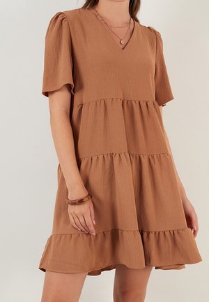 Vestido marrón de capas con escote en V y mangas cortas abullonadas. Confeccionado con tela texturizada y bajo con volantes. Acentuado con un diseño en capas.