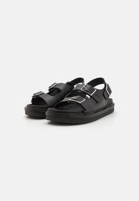 Svarta sandaler med en elegant design, tillverkade av gummi, med två justerbara spännen på ovansidan och en tjock, texturerad sula.