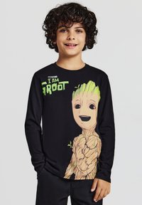 Maglietta nera a maniche lunghe con un grafico colorato di Groot e la scritta "IO SONO GROOT", realizzata in tessuto di cotone, con una texture morbida.