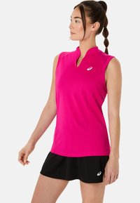 Top atletico senza maniche fucsia con collo alto, realizzato in tessuto liscio. Abbinato a una gonna nera con un piccolo accento di logo.