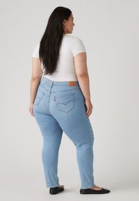 Ανοιχτό μπλε τζιν με ίσια γραμμή, με μέση μεσαίου ύψους και το λογότυπο της Levi's στο πίσω μέρος. Ομαλή υφή, κλασικός σχεδιασμός.