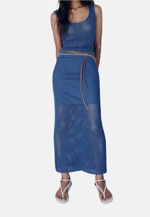 Ensemble en tricot bleu en deux pièces comprenant un haut sans manches et une jupe maxi. Le tissu est en trame ouverte avec un motif texturé, agrémenté d'une ceinture marron.