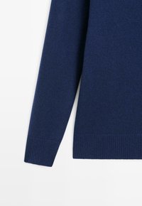 Maglione a maniche lunghe blu navy in maglia con polsini e orlo a coste, mostrato su sfondo bianco.