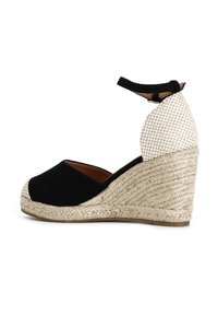 Sandali wedge in suede nero con tacco in seagrass intrecciato, caratterizzati da un retro a trama check e una cinghia alla caviglia. Design stabile e confortevole.