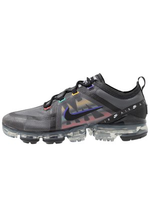 Czarny sneaker Nike Air VaporMax z przezroczystą podeszwą, wielokolorowymi oczkami na sznurówki i oznaczeniem Nike na boku oraz pasku na pięcie.