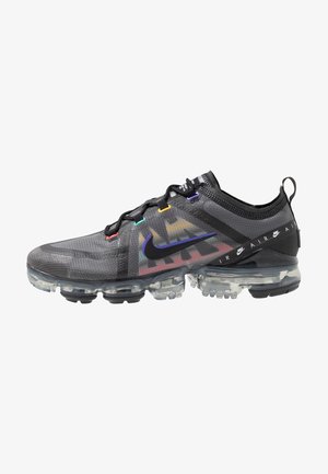 Czarny sneaker Nike Air VaporMax z przezroczystą podeszwą, wielokolorowymi oczkami na sznurówki i oznaczeniem Nike na boku oraz pasku na pięcie.