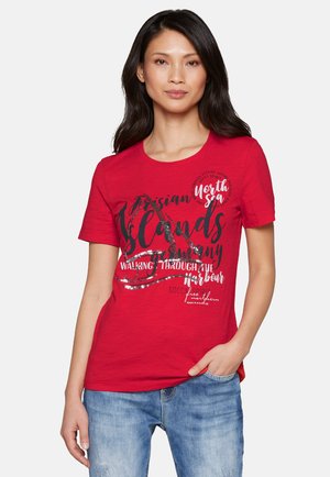 Rotes T-Shirt aus weichem Stoff, mit Rundhalsausschnitt und kurzen Ärmeln. Gedruckter Text in Schwarz und Silber, mit verschiedenen Designelementen und Phrasen.