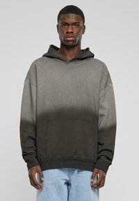 Hanorac cu gradient negru și gri, cu buzunar tip kangaroo, croială largă și manșete și tiv din material elastic, realizat din bumbac moale.