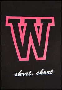 Svart stoff med en stor rosa bokstav "W" og frasen "skrrt, skrrt" i hvit kursiv under. Jevn tekstur, dristig trykkdesign.