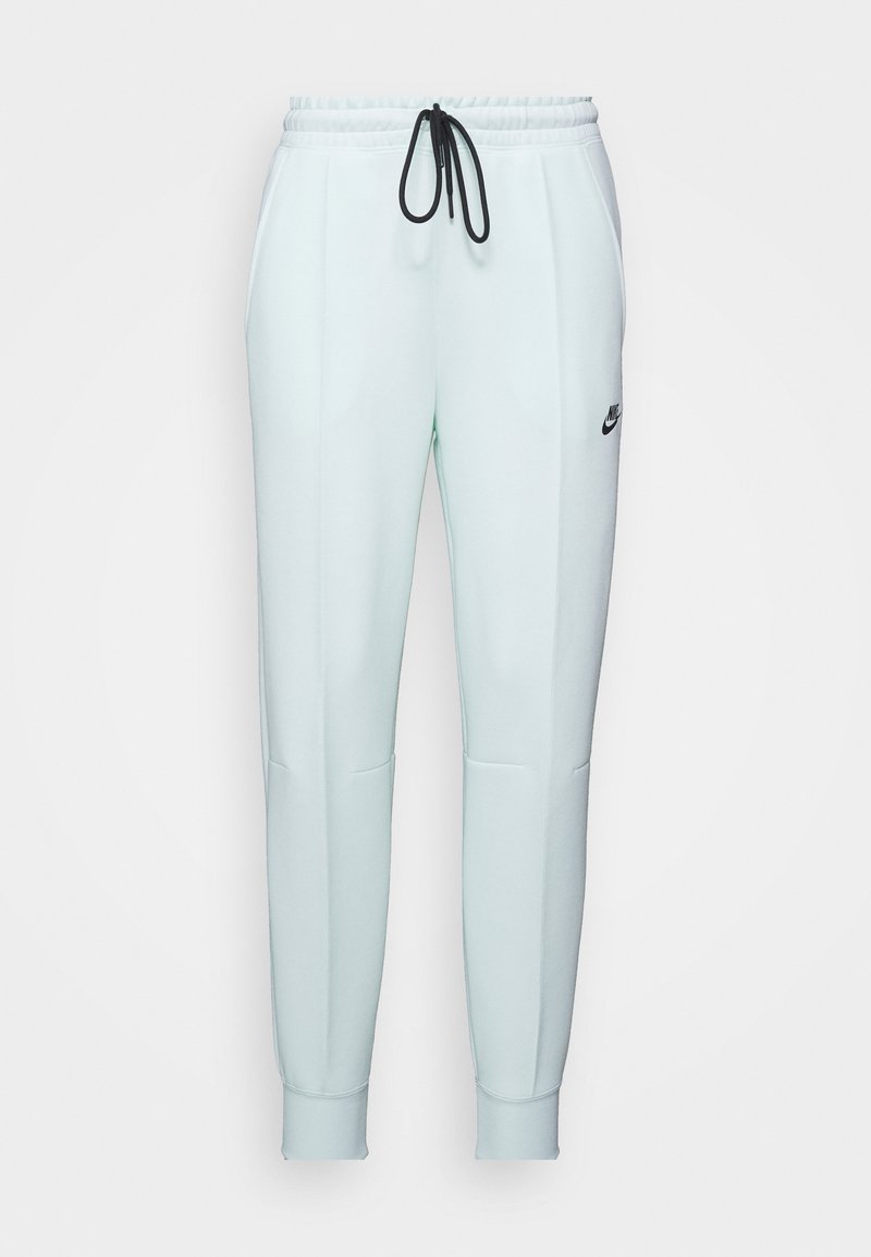 Pantaloni della tuta verde chiaro con vita regolabile, due tasche laterali, gambe svasate e logo Nike nero sulla coscia sinistra.