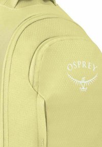 Tasca di uno zaino in tessuto verde chiaro con texture, con il logo bianco Osprey che presenta un uccello stilizzato con le ali spiegate.