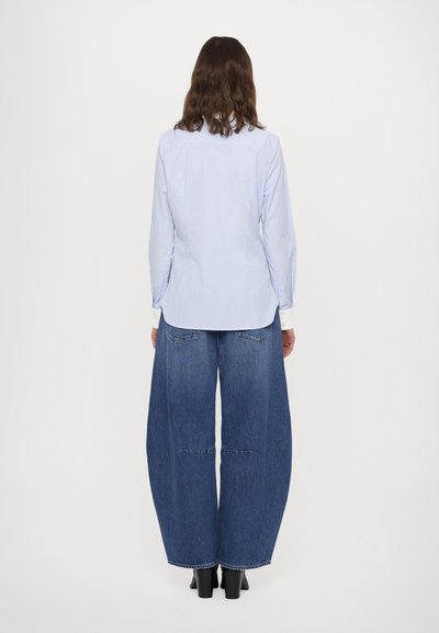Blue and white striped button-up shirt with long sleeves, paired with wide-leg blue denim pants, viewed from the back.