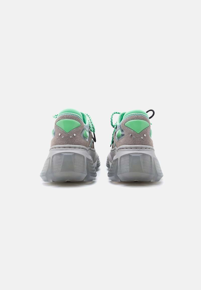 Paar graue und mintgrüne Sneaker, von hinten gezeigt, mit dicken transparenten Sohlen und gemusterten mintgrünen Schnürsenkeln.