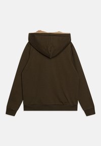 Brun hettegenser med myk, beige fôr på innsiden av hetten. Den har ribbestrikkede mansjetter og vrangbord, samt en avslappet passform uten frontlommer.