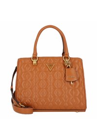 Tan, quiltad handväska med guldfärgad hårdvara, dubbla handtag och avtagbar rem. Har en logotavla och en charm-tagg för detaljer.