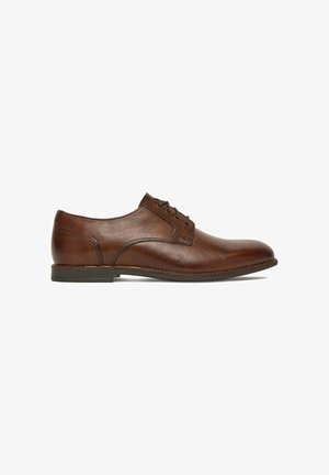 Brown leather men's dress shoe with lace-up closure, low stacked heel, and rounded toe, shown in side profile on white background.