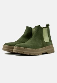 Stivaletti alla caviglia in suede verde con pannelli laterali elastici, suole in gomma e dettagli testurizzati sulla suola esterna. Presentano un anello di trazione sul retro.