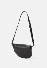 Borsa a spalla in pelle sintetica nera con una texture liscia, forma curvata, tracolla regolabile e design minimalista. Nessuna minuteria visibile.