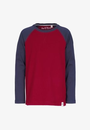 Pitkähihaisessa paidassa on punainen va body ja tummansiniset raglanhihet. Kangas on sileää, pyöreä kaula-aukko ja pieni tuotemerkki tarranurkassa.