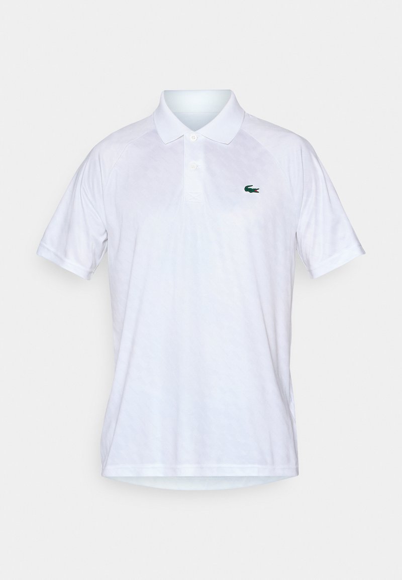 Polo shirt blanc en tissu léger avec un motif texturé, doté d'un col et d'un logo de crocodile vert sur la poitrine gauche.