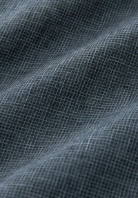 Tessuto tessile in grigio scuro con un delicato motivo a quadretti. Texture morbida con un leggero effetto lucido, che mostra pieghe delicate e profondità.