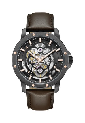 Kenneth Cole automatisk ur med sort og rosaguldfarvet skelet urskive, brun læderrem og synlige indre tandhjul, 12-timers markører.