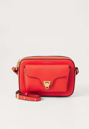 Sac bandoulière en cuir rouge texturé avec poche avant, fermoir doré, fermeture éclair et sangle réglable sur fond blanc.