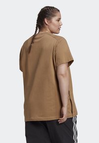 Bruine T-shirt met korte mouwen en een relaxte pasvorm, met zijsplitten, gemaakt van zachte katoenstof. Eenvoudig ontwerp zonder patronen.