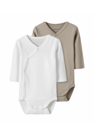 Kaksi pitkähihasta bodysuitia: yksi valkoinen, toinen beige. Molemmissa on kääntödesign, nepparit ja pehmeä, sileä puuvillakudos.
