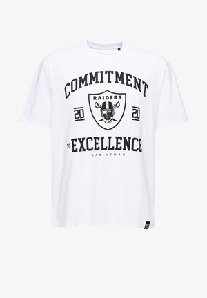 White cotton T-shirt featuring a large black graphic print with "COMMITMENT TO EXCELLENCE," "RAIDERS," and a helmet logo. Short sleeves, crew neck.