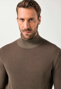 Brauner Strickpullover mit hohem Kragen, der ein strukturiertes Muster und gerippte Details am Hals aufweist, was eine enganliegende Passform zur Schau stellt.