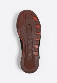 Schwarze und braune Sneakersohle aus strukturiertem Gummi, mit einem auffälligen "BIMBA Y LOLA"-Logo und Traction-Rillen für besseren Grip.