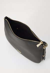 Black leather handbag with a textured surface, gold-tone zippers, and a flat design. Features a spacious interior and an adjustable strap.
