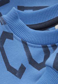 Sweatshirt blu in cotone con colletto girocollo a costine, evidenti motivi geometrici grigio scuro e una finitura morbida e texture.