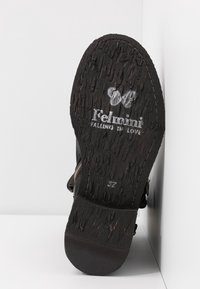 semelle de chaussure noire avec surface texturée, présentant la marque "Fellmini" et l'inscription "Falling in Love" en blanc, taille 37 visible.