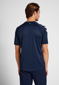 T-shirt de sport bleu marine en tissu anti-humidité, avec des manches courtes et des accents blancs sur les épaules, texture lisse et coupe décontractée.
