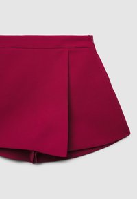 Gonna plissettata fucsia con design strutturato, texture liscia e zip nascosta sul retro. Orlo arrotondato.