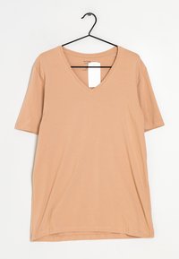 T-shirt beige a V-collo con maniche corte, realizzato in un tessuto morbido e liscio. Presenta un'etichetta appesa al colletto.