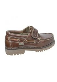 Zapato de cuero marrón con correa de velcro, suela resistente y costuras en contraste. Presenta detalles metálicos y un forro suave y texturizado.