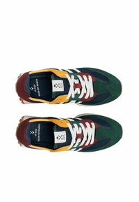 Zapatilla multicolor que presenta ante verde, acentos de malla, superposiciones en amarillo y marrón, cordones blancos y una suela de goma con un diseño estampado.