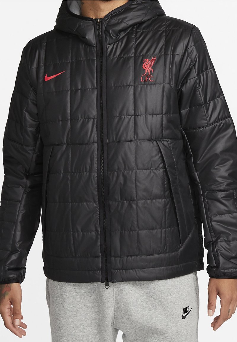 Veste noire rembourrée avec capuche, dotée d'une fermeture éclair à l'avant, d'un motif matelassé subtil et du logo rouge de Liverpool FC sur la poitrine.