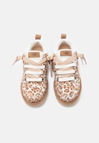 Baskets à imprimé léopard avec des accents beiges, des lacets blancs et une semelle en caoutchouc beige. Logo UGG visible sur la languette et le côté de la chaussure.