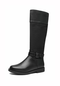 Botte haute en cuir noir et daim avec un petit talon et une bride décorative avec boucle autour de la cheville sur fond blanc.