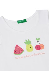 Canottiera bianca in cotone con grafiche di frutta colorate: un'anguria rosa, un'ananas verde e delle ciliegie rosse, con il testo "United Colors of Benetton".