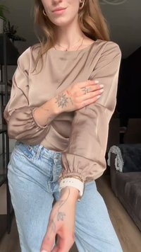 Lange mouw, beige satijnen top met opgeblazen mouwen, geplooide manchetten en een relaxed fit, gecombineerd met lichtblauwe denim jeans.