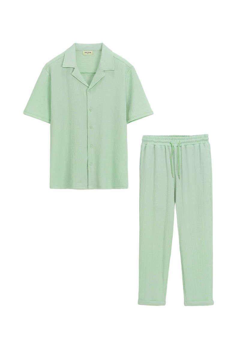 Chemise boutonnée à manches courtes vert clair avec une coupe décontractée et pantalon à taille élastique en tissu et couleur assortis. Design texturé.