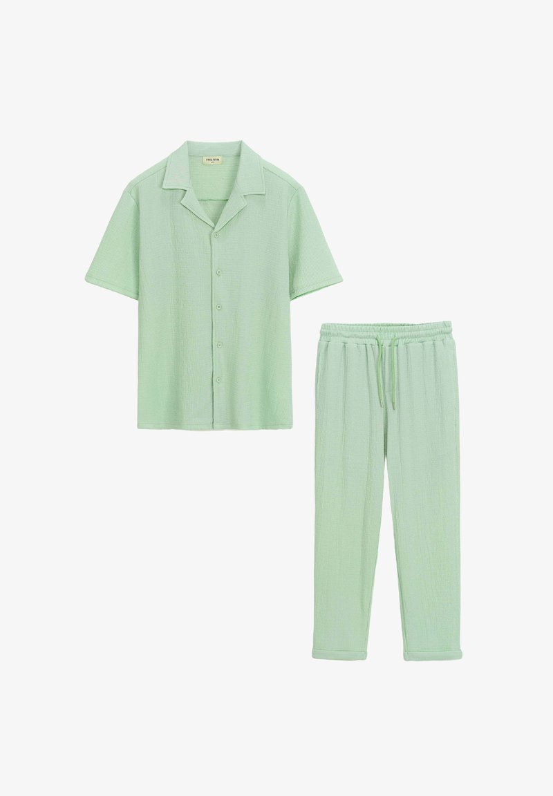 Chemise boutonnée à manches courtes vert clair avec une coupe décontractée et pantalon à taille élastique en tissu et couleur assortis. Design texturé.