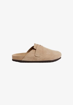Beige suède instap schoenen met een ronde neus, minimalistisch ontwerp en een gestructureerde zool voor grip. Vouwriem accentueert de details.