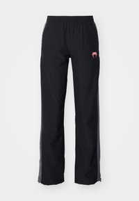 Svarte utebukser med elastisk midje, sidelommer og rosa logo. Har en rett ben design og kontrasterende grå detaljer.