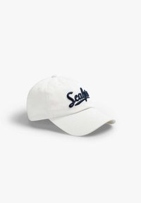 Witte katoenen baseballcap met een marineblauwe geborduurde "Scalpers"-logo op de voorkant. Heeft een gebogen rand en een verstelbare band aan de achterkant.